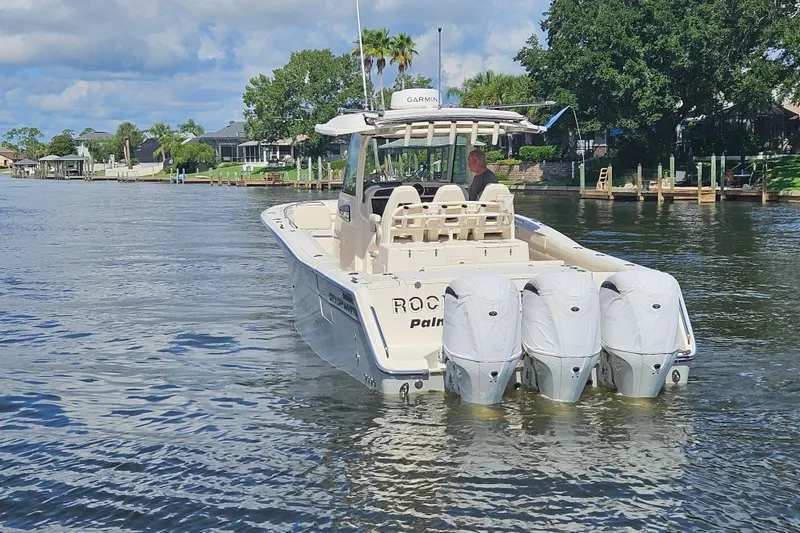 Slide: The Image of 2022 Grady-White Canyon 336 boat cruising on a scenic waterway with triple engines. - 14