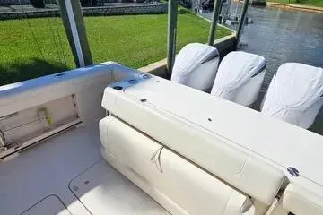 Slide: The Image of 2022 Grady-White Canyon 336 boat with triple engines docked by the water. - 15