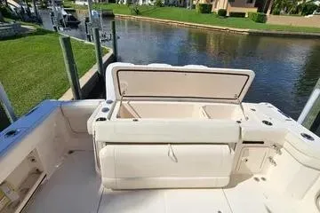 Slide: The Image of 2022 Grady-White Canyon 336 boat interior with open storage compartment by a waterfront. - 19