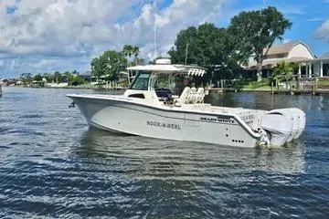 Slide: The Image of 2022 Grady-White Canyon 336 boat on a calm river with scenic background. - 5