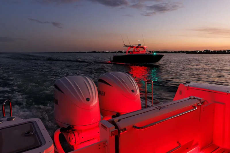 Slide: The Image of Sunset view of Solara S-310 SB boat on water, illuminated by red lights. - 18