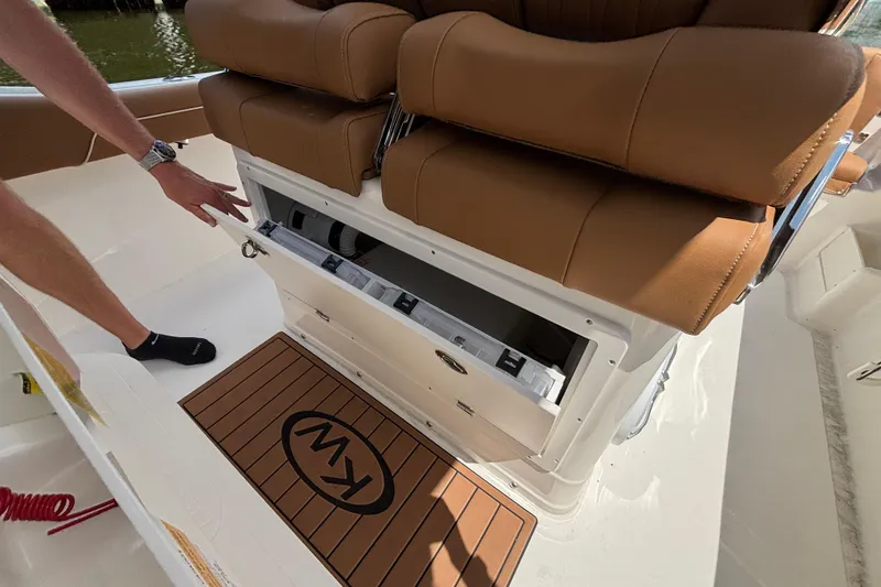 Slide: The Image of 2026 Key West 239 FSR boat interior with storage compartment and cushioned seating. - 11