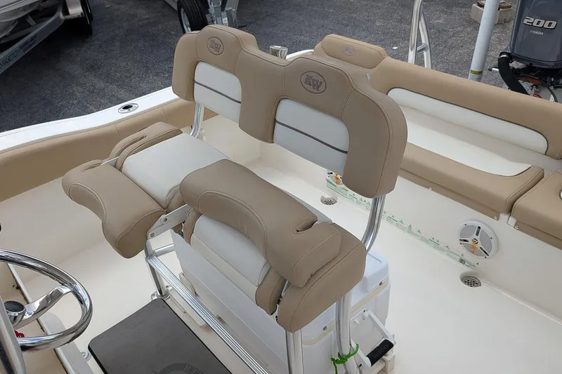 Slide: The Image of 2014 Key West 219 FS boat interior with beige seating and steering wheel. - 12