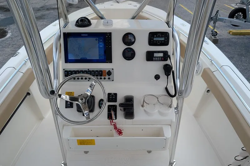 Slide: The Image of 2014 Key West 219 FS boat console with steering wheel, navigation, and communication equipment. - 13