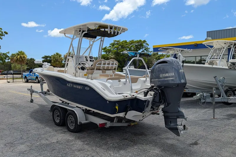 Slide: The Image of 2014 Key West 219 FS boat with Yamaha engine on trailer, parked outdoors. - 2