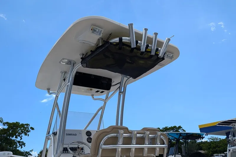 Slide: The Image of 2014 Key West 219 FS boat with T-top and rod holders under clear blue sky. - 20