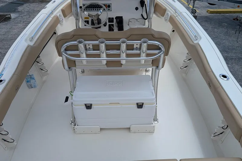 Slide: The Image of 2014 Key West 219 FS boat interior with seating, steering console, and cooler. - 9