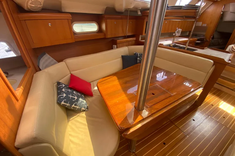 Slide: The Image of Luxurious interior of 2003 Hunter 386 sailboat with wooden table and cushioned seating. - 11