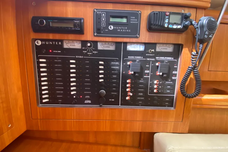 Slide: The Image of Electrical control panel on a 2003 Hunter 386 sailboat, featuring various switches and monitors. - 14