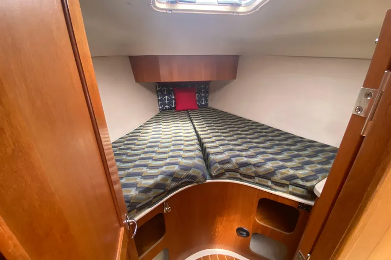 Slide: The Image of Cozy cabin interior of 2003 Hunter 386 sailboat with patterned bedding and wooden finish. - 21
