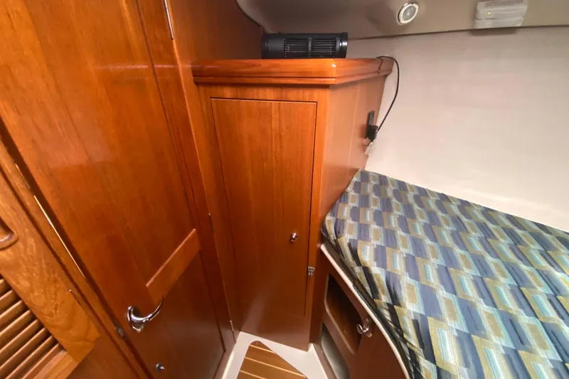 Slide: The Image of Interior cabin of 2003 Hunter 386 sailboat with wooden cabinetry and patterned bedding. - 23