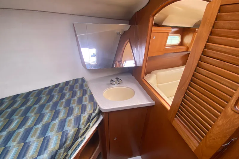 Slide: The Image of Interior of 2003 Hunter 386 sailboat with sink, mirror, and patterned bedding. - 25