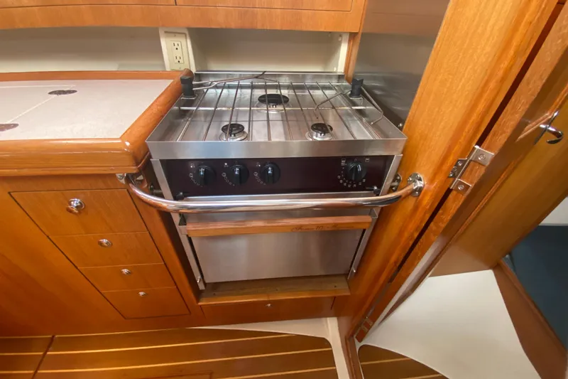 Slide: The Image of Compact kitchen area in a 2003 Hunter 386 yacht with a stainless steel stove. - 29