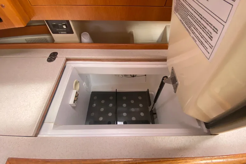Slide: The Image of Open storage compartment in 2003 Hunter 386 yacht interior, featuring a hinged lid and organized space. - 31