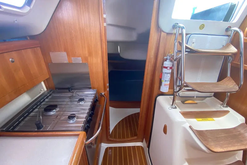 Slide: The Image of Interior of 2003 Hunter 386 sailboat with wooden cabinetry and compact kitchen area. - 32