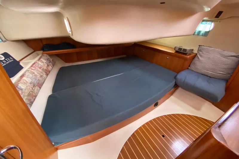 Slide: The Image of 2003 Hunter 386 yacht interior cabin with blue bedding and wooden accents. - 33