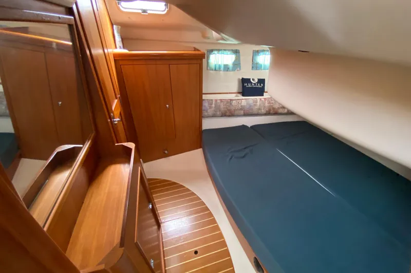Slide: The Image of 2003 Hunter 386 yacht interior with wooden cabinetry and cozy sleeping area. - 34