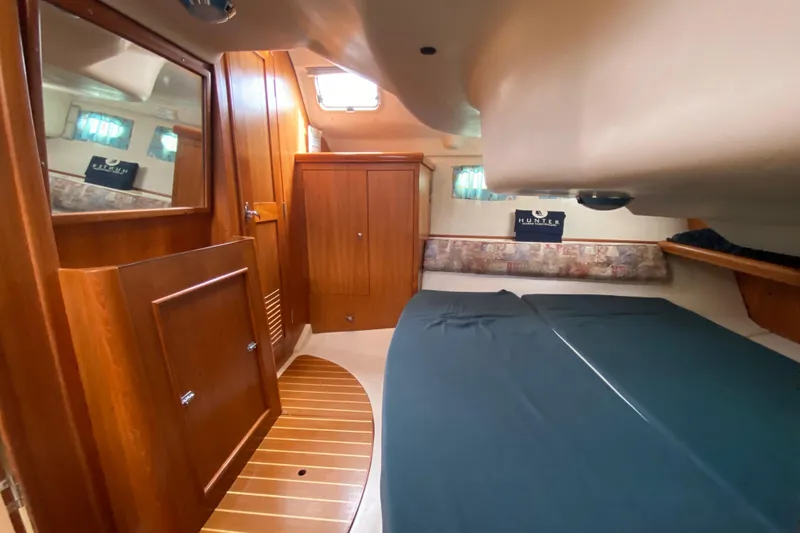 Slide: The Image of Interior cabin of a 2003 Hunter 386 sailboat with wooden furnishings and a cozy bed. - 35