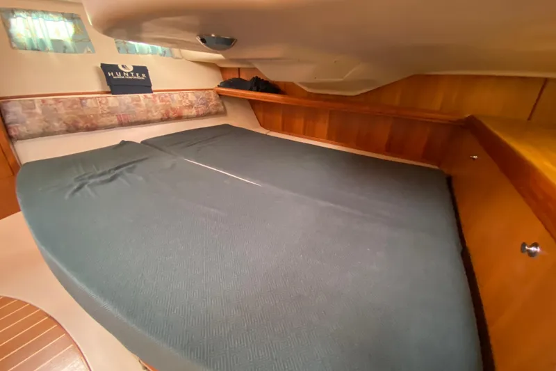 Slide: The Image of Interior cabin of 2003 Hunter 386 sailboat with wooden accents and comfortable bedding. - 36