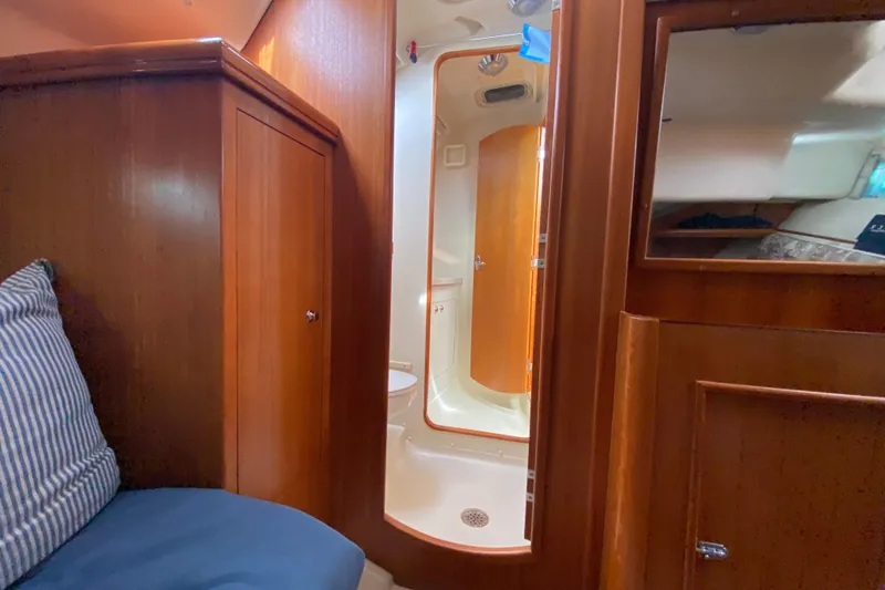 Slide: The Image of Interior of 2003 Hunter 386 sailboat featuring wooden cabinetry and compact bathroom. - 40