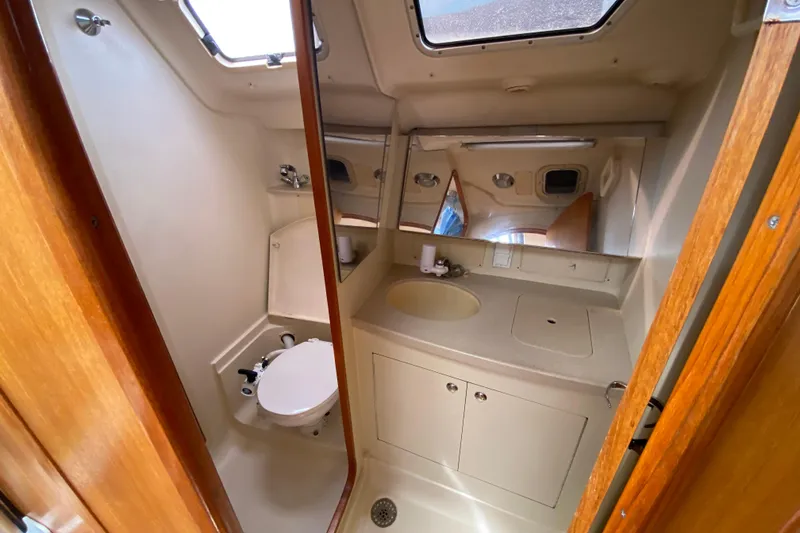 Slide: The Image of 2003 Hunter 386 yacht bathroom with sink, toilet, and mirror. - 41