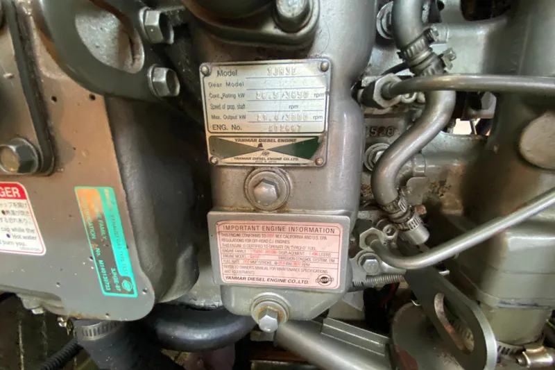 Slide: The Image of Close-up of a Yanmar diesel engine with informational labels and metal components. - 48