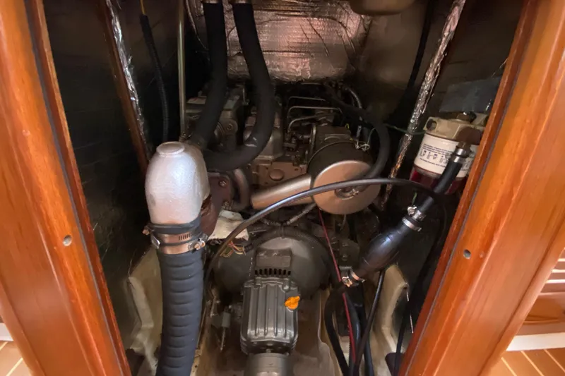 Slide: The Image of Engine compartment of a 2003 Hunter 386 sailboat, showcasing mechanical components and hoses. - 51