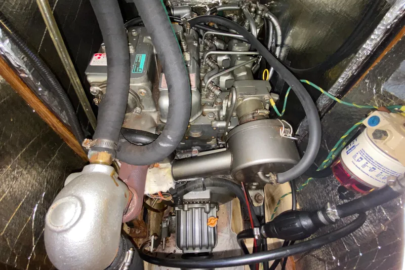 Slide: The Image of Engine compartment of a 2003 Hunter 386 sailboat, showcasing mechanical components and hoses. - 52