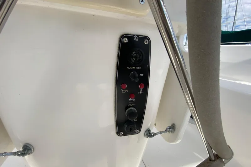 Slide: The Image of Control panel on a 2003 Hunter 386 sailboat, featuring alarm and start buttons. - 61