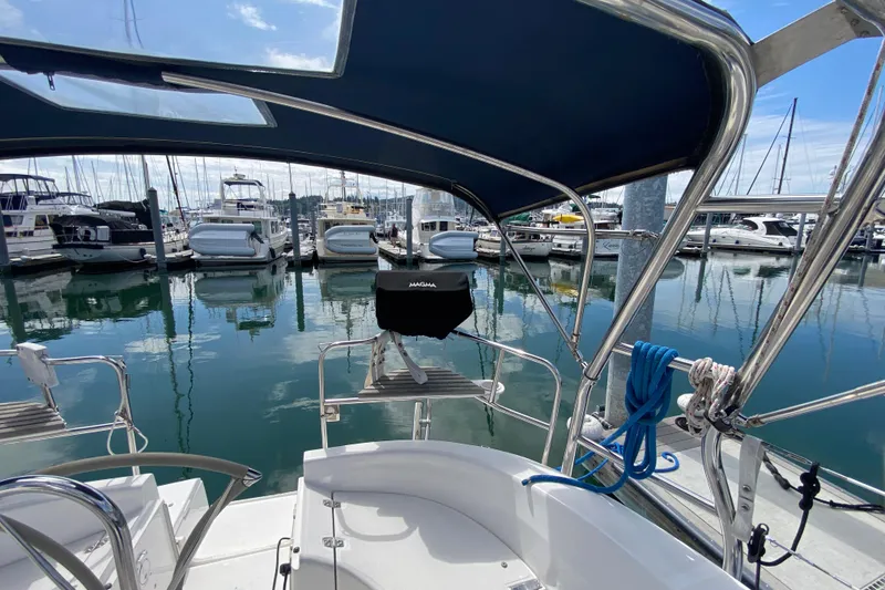 Slide: The Image of Hunter 386 sailboat cockpit view in marina, showcasing sleek design and moored yachts. - 65
