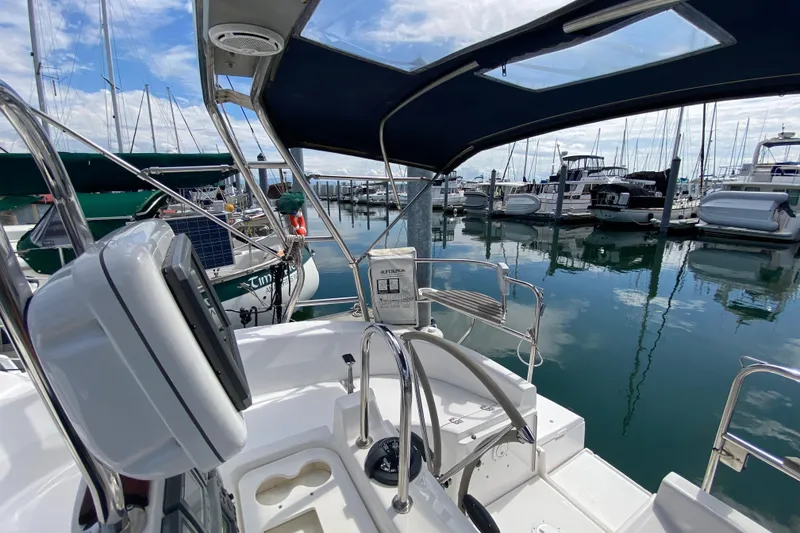 Slide: The Image of 2003 Hunter 386 sailboat cockpit view in marina, surrounded by docked boats. - 66