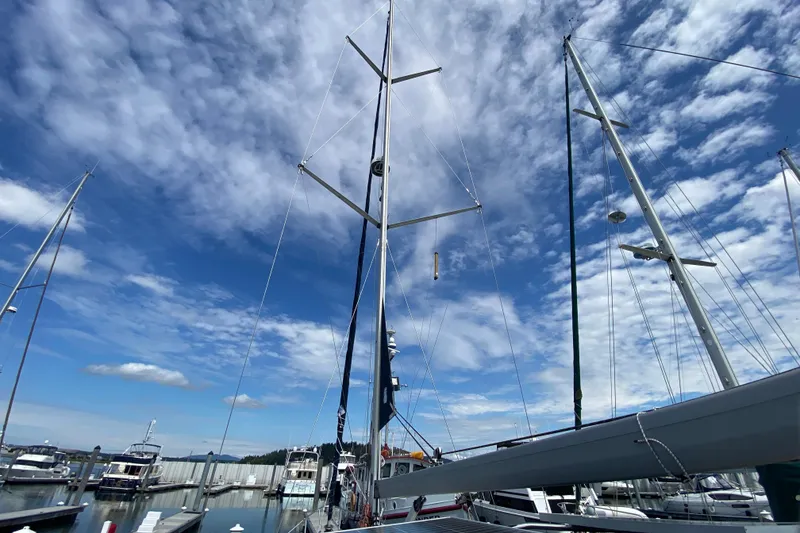 Slide: The Image of Sailboat masts at a marina under a partly cloudy sky, featuring a 2003 Hunter 386. - 71