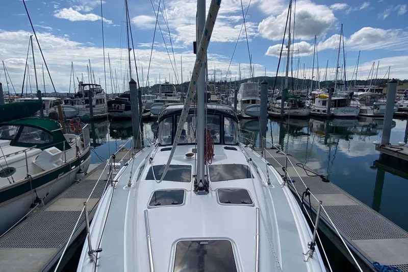 Slide: The Image of 2003 Hunter 386 sailboat docked in a marina, surrounded by other boats under a cloudy sky. - 77