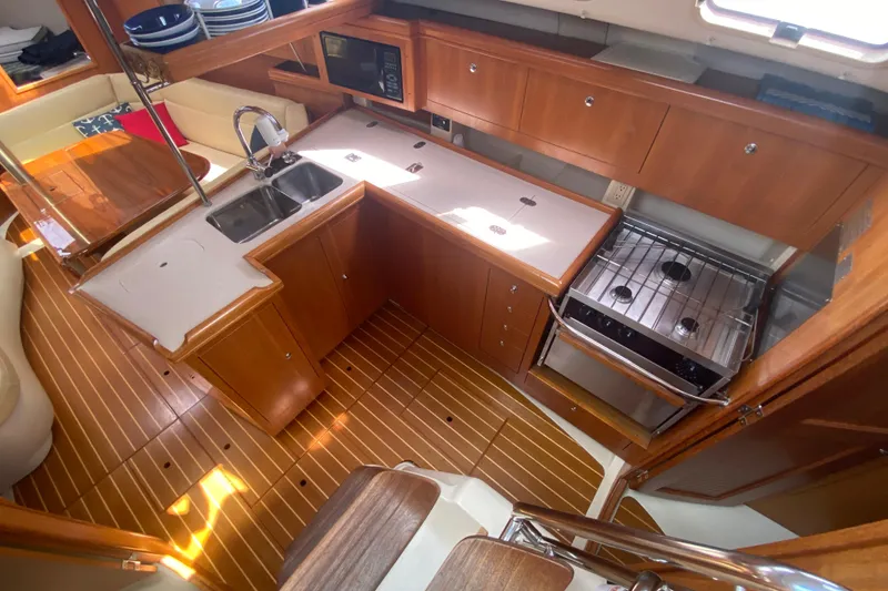 Slide: The Image of 2003 Hunter 386 yacht interior kitchen with wood cabinetry, dual sink, and stove. - 8