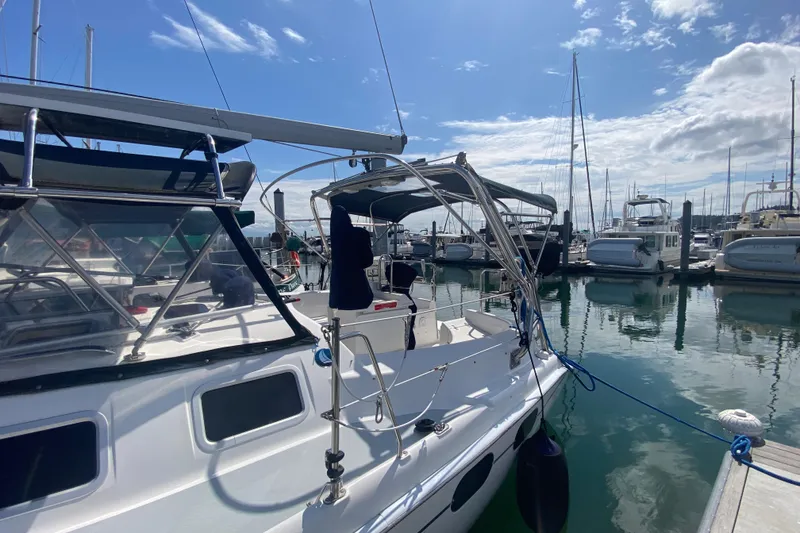 Slide: The Image of 2003 Hunter 386 sailboat docked at a marina under a clear blue sky. - 82