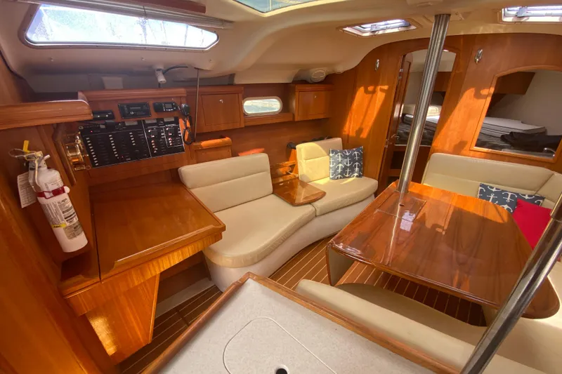 Slide: The Image of Luxurious 2003 Hunter 386 yacht interior with wood finish, seating, and navigation panel. - 9
