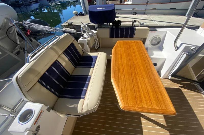 Slide: The Image of 2019 Ranger Tugs R-29 S cockpit with striped seating and wooden table. - 30