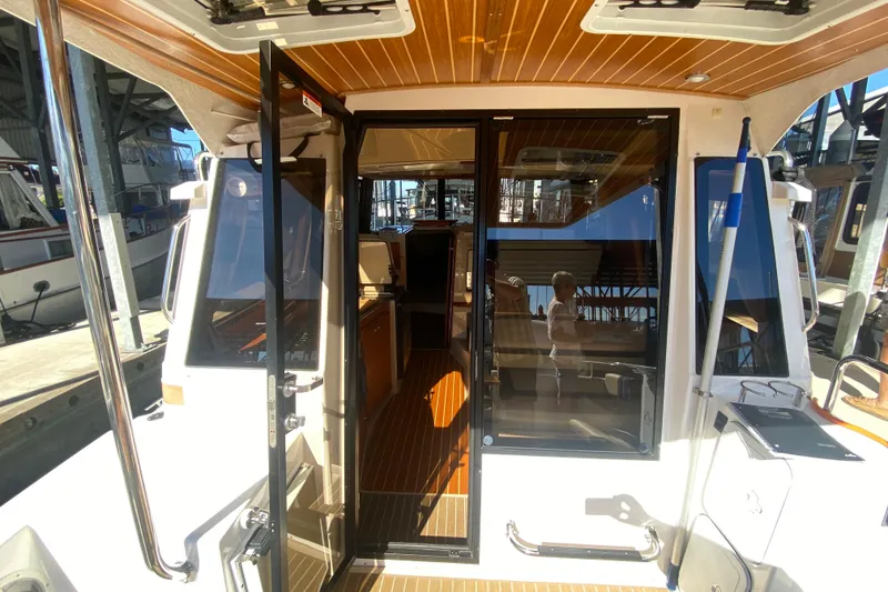 Slide: The Image of 2019 Ranger Tugs R-29 S boat interior with open glass doors and wooden flooring. - 34