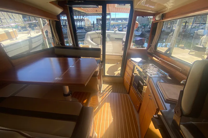 Slide: The Image of 2019 Ranger Tugs R-29 S interior with dining area, kitchen, and outdoor view. - 37