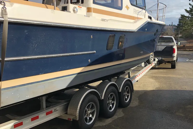 Slide: The Image of 2019 Ranger Tugs R-29 S boat on trailer, hitched to a truck. - 4