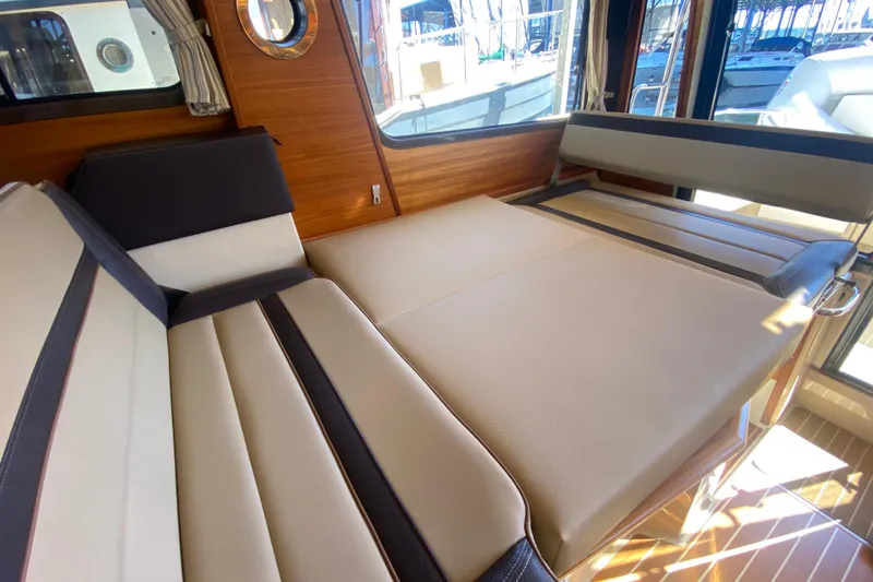 Slide: The Image of 2019 Ranger Tugs R-29 S interior with convertible seating and wood accents. - 42