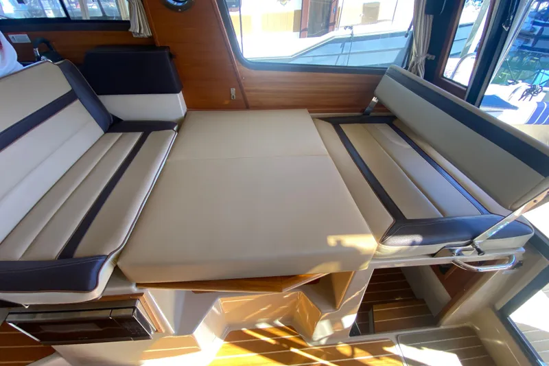 Slide: The Image of Interior seating of 2019 Ranger Tugs R-29 S boat, featuring convertible cushioned benches. - 43