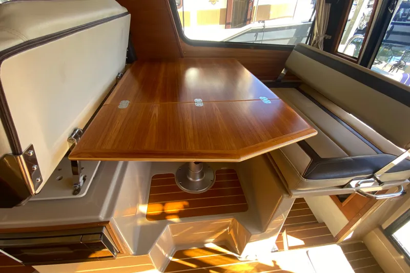 Slide: The Image of 2019 Ranger Tugs R-29 S interior with wooden table and cushioned seating. - 44