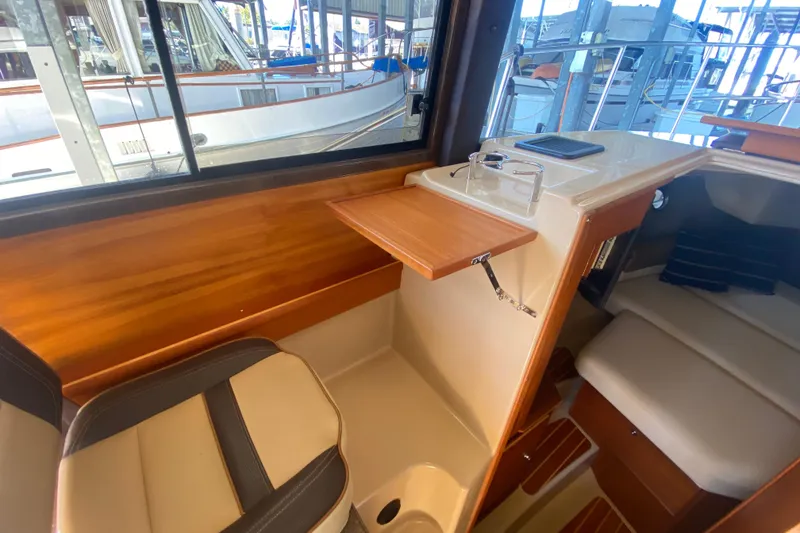 Slide: The Image of 2019 Ranger Tugs R-29 S interior with wood accents and seating area. - 49