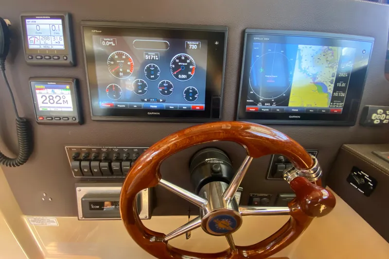 Slide: The Image of Dashboard of 2019 Ranger Tugs R-29 S with Garmin navigation displays and wooden steering wheel. - 52