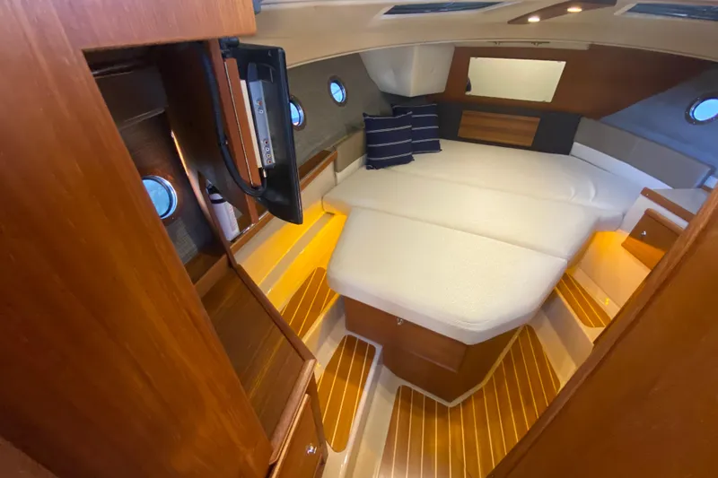 Slide: The Image of 2019 Ranger Tugs R-29 S cabin interior with cozy bed and wooden accents. - 61