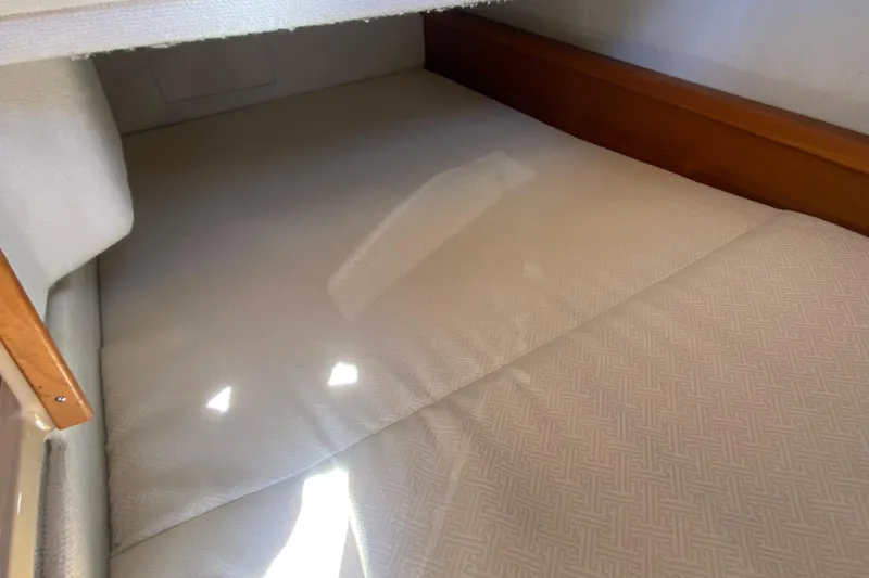 Slide: The Image of 2019 Ranger Tugs R-29 S interior cabin with cushioned bed and wooden trim. - 70