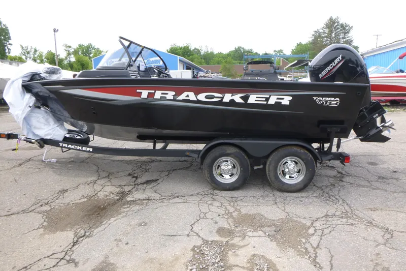 Slide: The Image of 2026 Tracker Targa V-18 WT boat on trailer, black with red accents, parked outdoors. - 3
