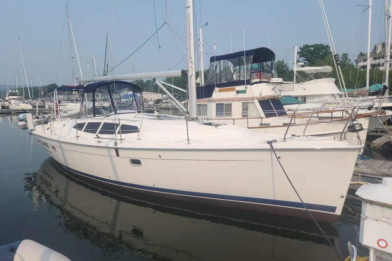 The Image of 2011 Hunter 39 sailboat docked at a marina, surrounded by other boats. - 0