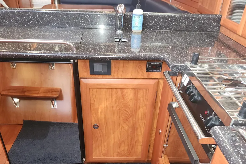 Slide: The Image of 2011 Hunter 39 yacht kitchen with granite countertops and wooden cabinetry. - 10